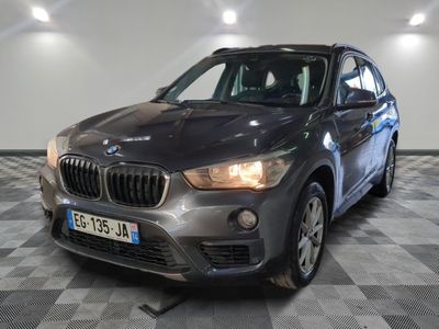 la bmw x1 est garée dans une grande pièce au sol en damier