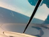 a close up of a car door handle with a reflection of a person in the mirror