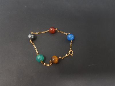a close up of a gold chain bracelet with multi colored beads