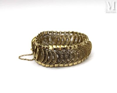 a close up of a bracelet with a chain on a white surface
