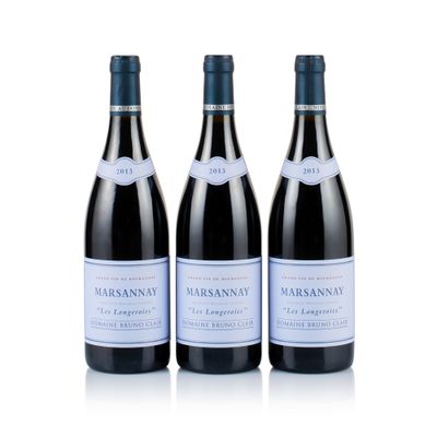 three bottles of wine sit on a white surface