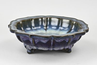 bol en céramique violet et bleu posé sur un socle, sur fond blanc