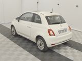 a small white car parked in a room with a checkered floor