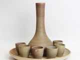 a picture of a vase and cups on a plate