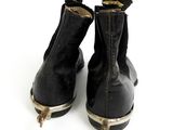 a pair of black boots that are on a white surface