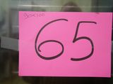 un panneau rose sur lequel est inscrit le chiffre 65