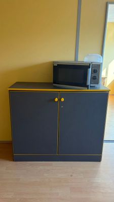 un micro-ondes posé sur un meuble dans une pièce