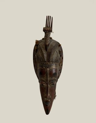 an image of a wooden mask hanging on a wall
