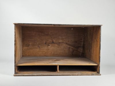 une vieille boîte en bois comportant deux compartiments ouverts, posée sur une surface blanche