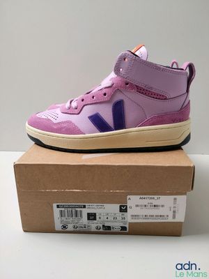 un gros plan sur une paire de chaussures violettes posées sur une boîte