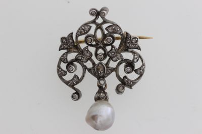 un gros plan d'un pendentif en perle et diamant sur fond blanc