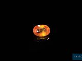 an orange sapphire stone on a black surface