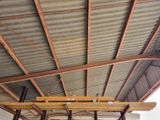 a picture of a ceiling with metal roofing and wood beams
