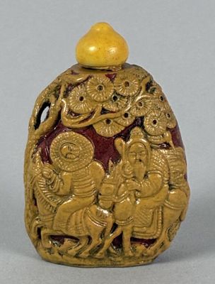 an image of a gold and red snuff bottle with figures on it