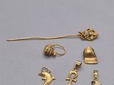 Plusieurs bijoux en or sont exposés sur un fond blanc