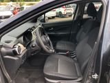 the interior of a car with the door open and the driver ' s seat down