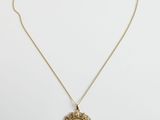 un collier en or avec une pièce de monnaie sur une chaîne