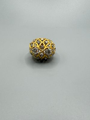 gros plan d'une bague en or et diamants sur une surface blanche