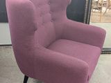 fauteuil rembourré violet placé devant un miroir dans une pièce
