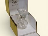 a glass perfume bottle in a box on a white surface