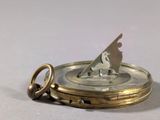 a close up of a pocket watch with a key on it