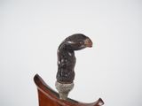 a statue of a bird sitting on top of a wooden stand