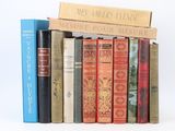 several books are stacked on top of each other on a white surface