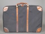 a black suitcase with a brown handle on a gray background