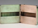 an open book with a green cover sitting on a table