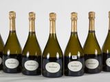 six bouteilles de vin sont alignées sur une table