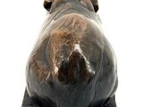 statue of a bull laying down on a wooden base