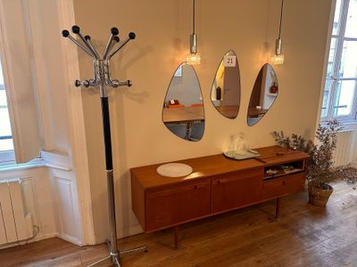 three mirrors hanging on the wall above a wooden dresser