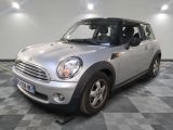 une petite voiture argentée garée sur un sol en damier