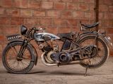a old motorcycle that is parked in front of a brick wall