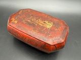 an old red box sitting on top of a black table