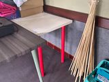 a broom and a broom stand next to a table in a room