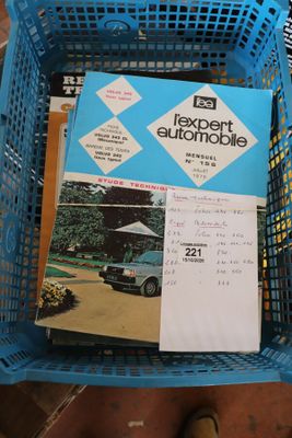 un panier bleu rempli de livres et de magazines posé par terre