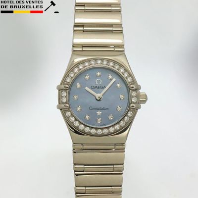 un gros plan d'une montre sur une surface blanche avec un fond blanc
