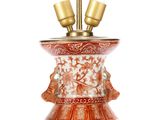 a red and white vase with two birds on top of it