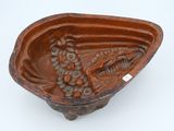 a brown bowl with a fish in it on a white surface