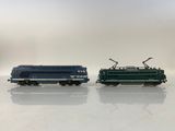 two blue and green trains sitting side by side on a white surface