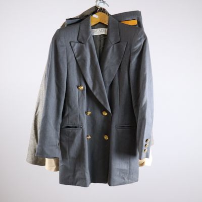 grey double breasted blazer with gold buttons on a hanger