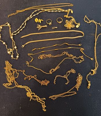 a lot of gold necklaces and bracelets on a table