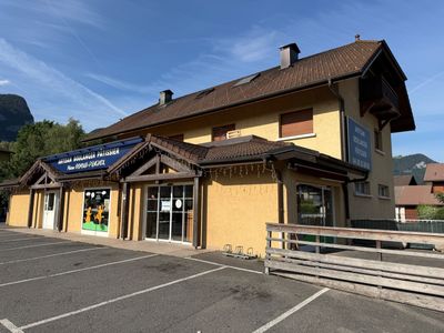 un parking situé devant un immeuble, avec un banc devant celui-ci