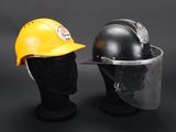 pair of yellow and black hard hats and a helmet on a mannequin head