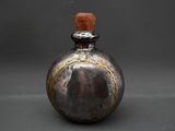a small bottle with a wooden top sitting on a table