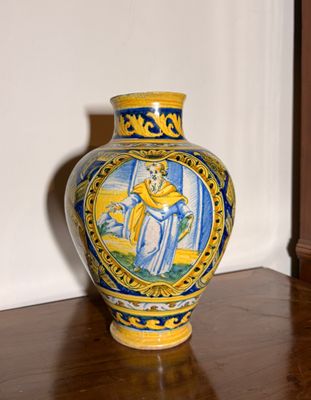 un vase jaune et bleu posé sur une table en bois
