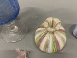 a glass vase and a small pumpkin sitting on a table