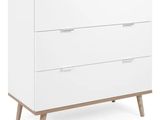 a white chest of drawers with wooden legs and drawers