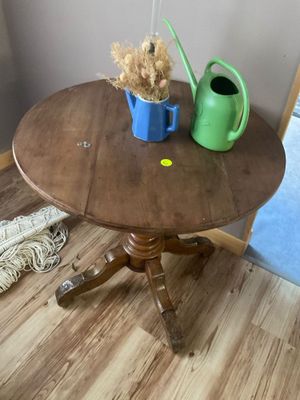 une petite table sur laquelle se trouvent un arrosoir et un autre arrosoir